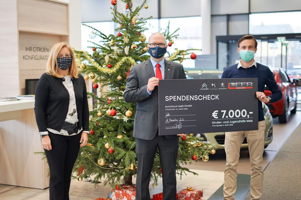 Scheckübergabe im Autohaus Leeb mit Christbaum im Hintergrund. Im Bild zu sehen sind Frau Vzbgm. Raggl-Mühlberger, Dienstellenleiter der Kinder- und Jugendhilfe Mag. Pantlitschko und Geschäftsführer Autohaus Leeb GmbH Stefan Leeb.