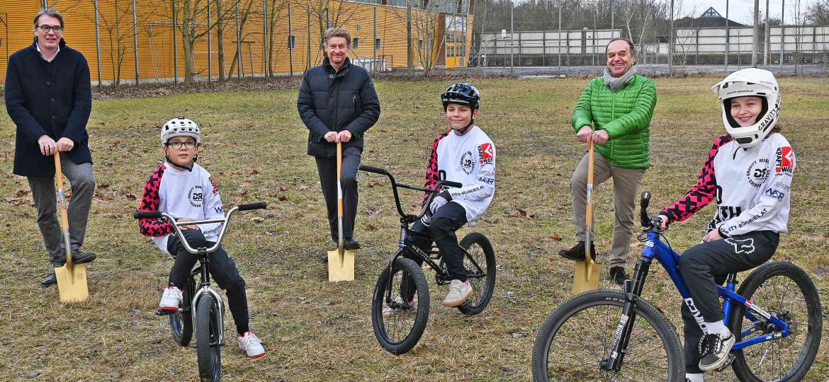 Vizebürgermeister Kroiß mit 2 Vertretern des RSW Vereins und Schaufeln in der Hand. 3 Kinder und Jugendliche mit Rädern und Schutzhelm im Vordergrund