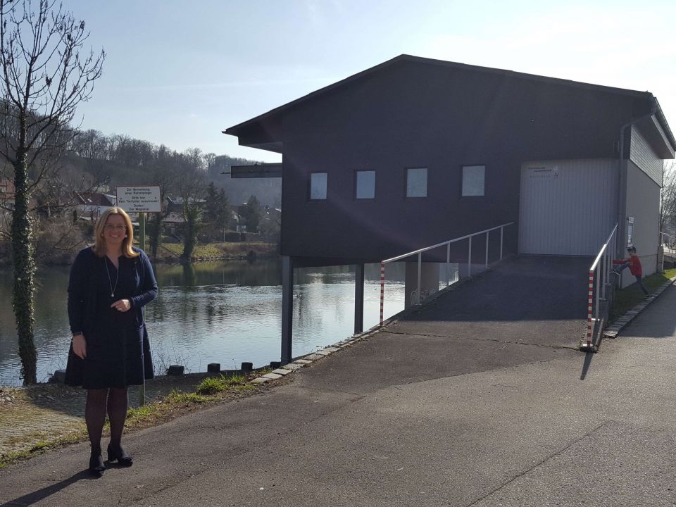 Frau Vizebürgermeister Raggl-Mühlberger steht vor dem Feuerwehrbootshaus an der Traun