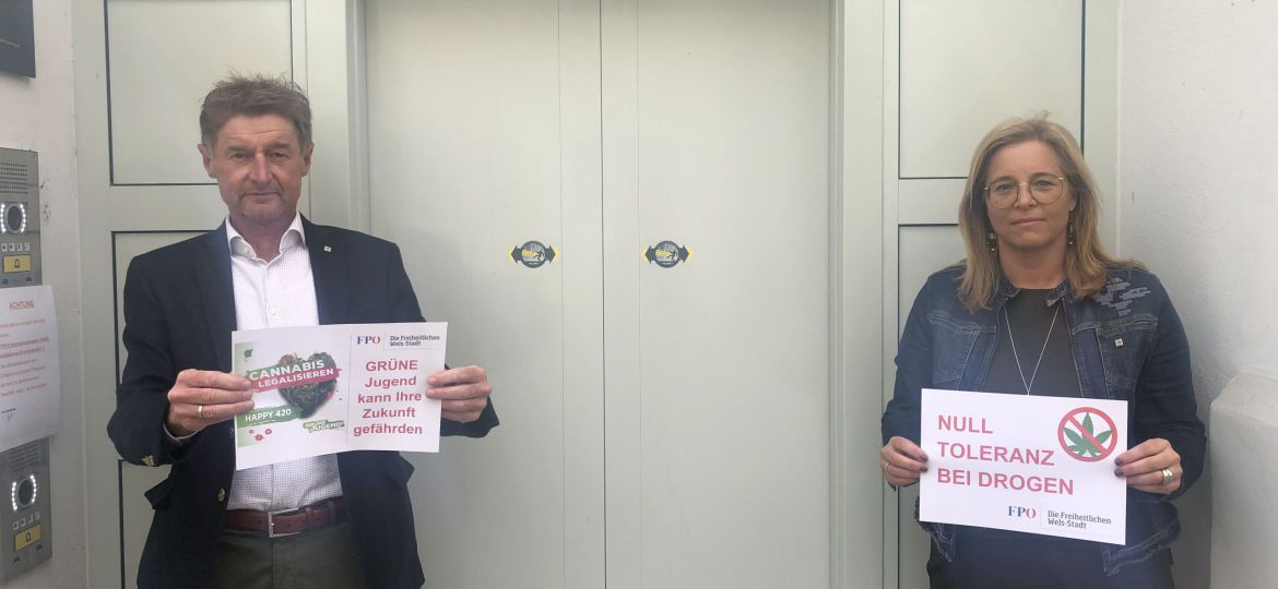 Gerhard Kroiß und Christa Raggl-Mühlberger stehen vor der Tür der Justizanstalt Wels mit Hinweisschildern 
