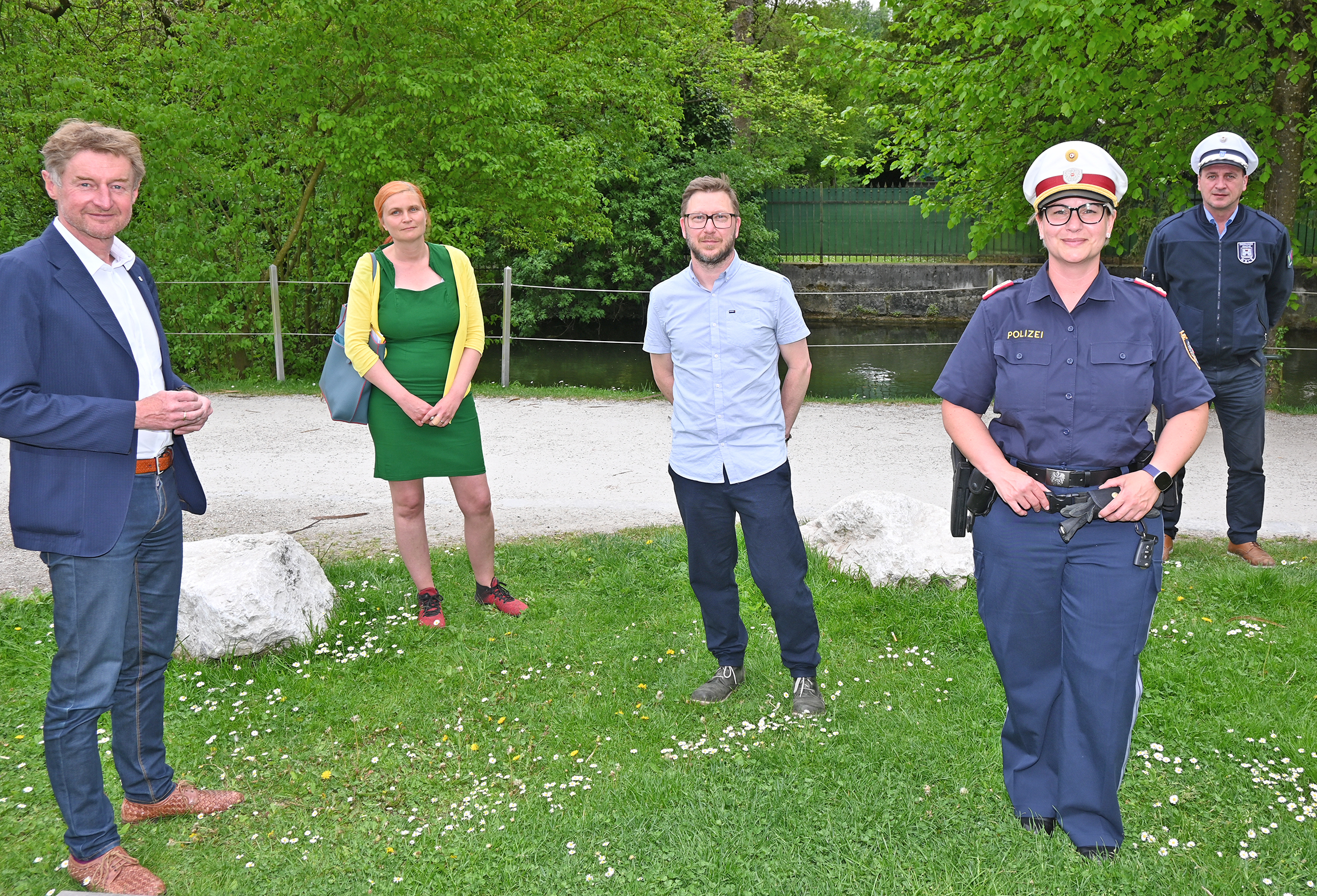 Vizebürgermeister Gerhard Kroiß steht mit den Vertretern der Polizei, der Ordnungswache und der Volkshilfe mit Abstand auf einer Wiese am Welser Zwinger