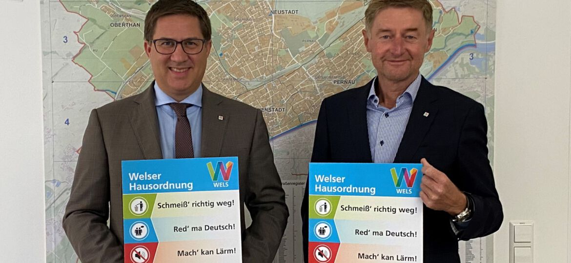 Bürgermeister Dr. Rabl und Vizebürgermeister Kroiß mit der Welser Hausordnung vor der Wels-Landkarte