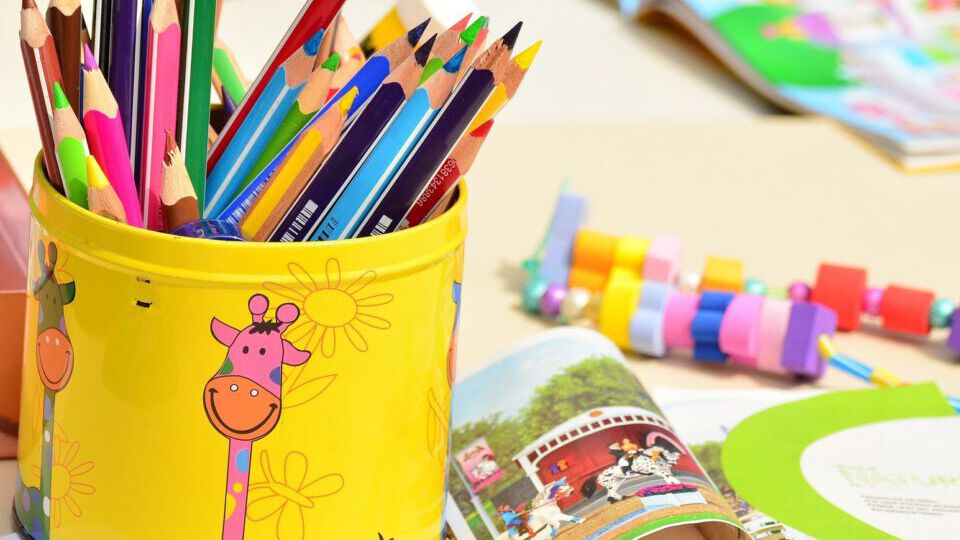 Kinderbetreuungseinrichtung: Buntstifte, Buch und Spielsachen
