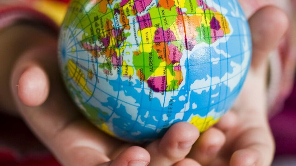Kinderhände halten Weltkugel in der Hand