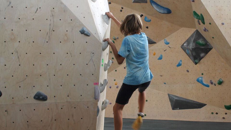 Kind an der Kletterwand