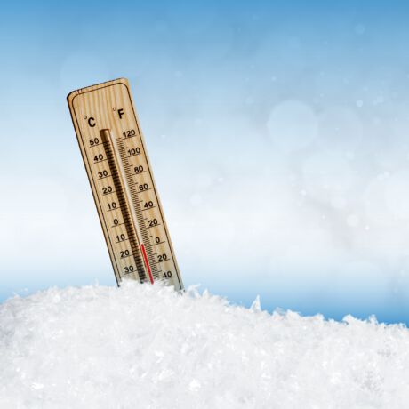 Ein Thermometer steckt im Schnee
