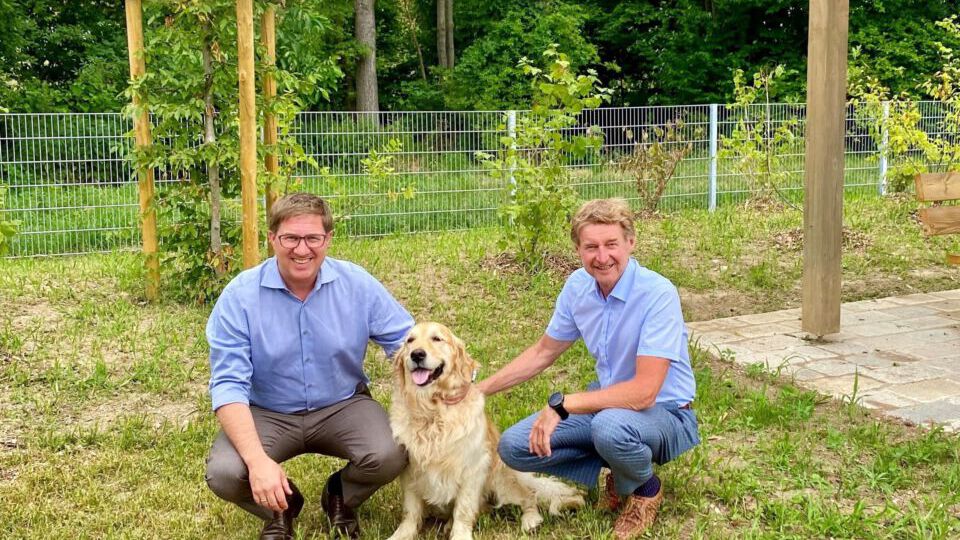 Bürgermeister Dr. Rabl und Vizebürgermeister Kroiß gemeinsam mit einem Hund in der neuen Hundefreilaufzone Pernau