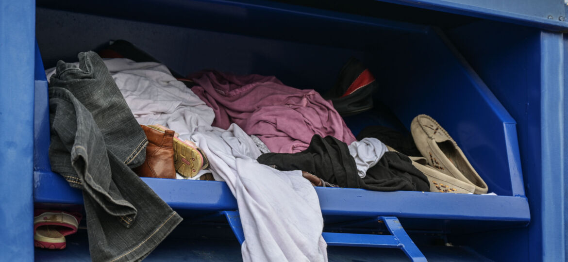 Lots of old dresses and shoes in a cloth donation container
