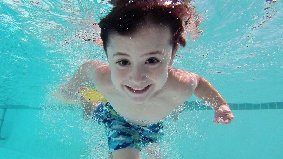 Kind unter Wasser in einem Pool